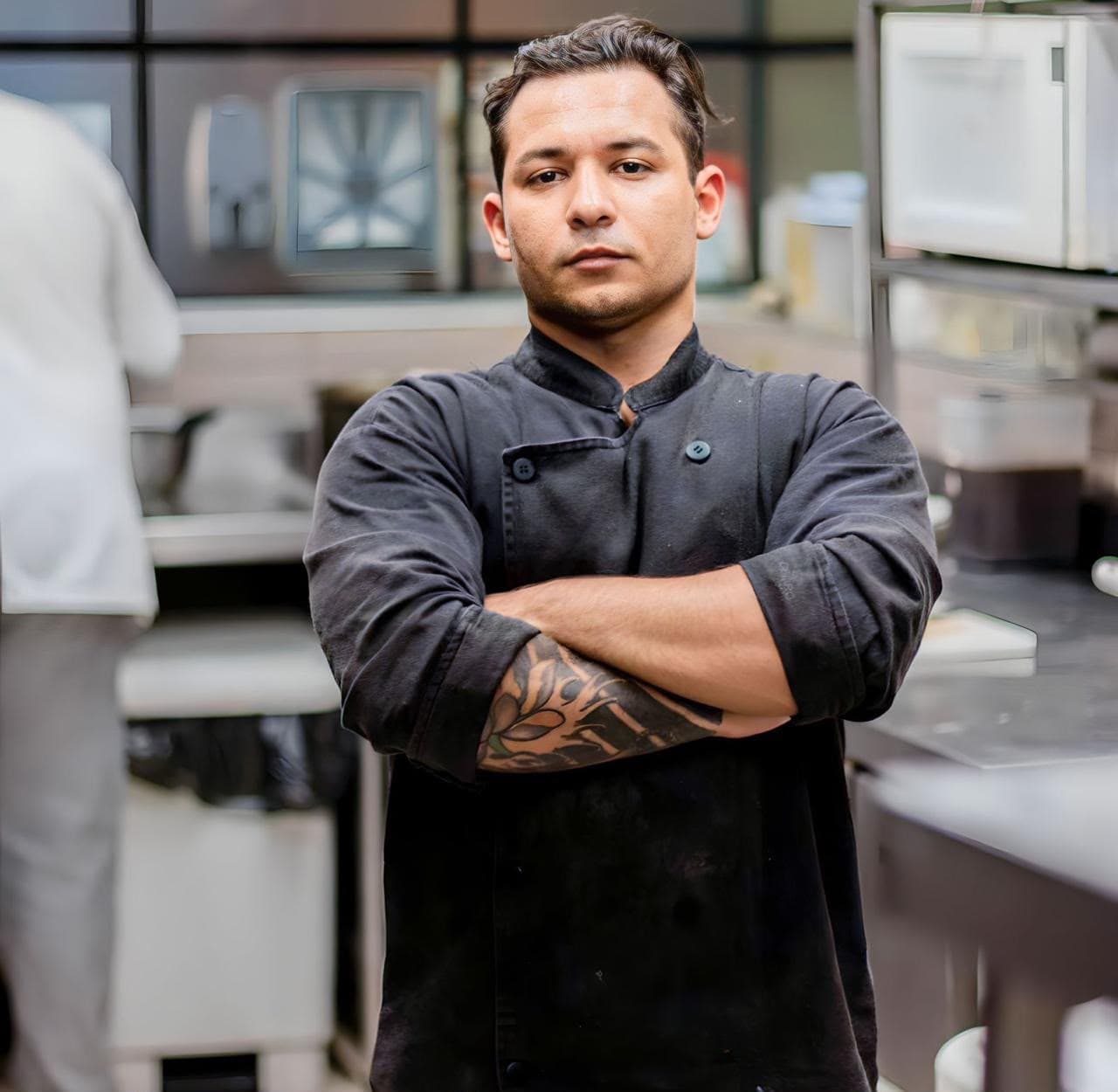 Retrato do chef de braços cruzados na cozinha